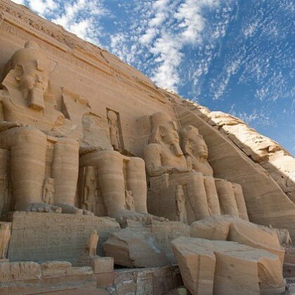 The Great Temple of Abu Simbel Temples carved into sandstone cliffs, featuring colossal statues of Pharaoh Ramesses II under a bright blue sky in southern Egypt.