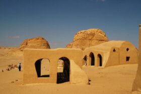 Ancient mudbrick ruins in Fayoum Desert Egypt surrounded by golden sand dunes