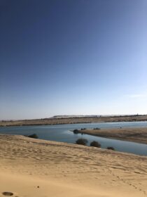 Scenic desert lake surrounded by sand dunes during a Fayoum holiday tour in Egy